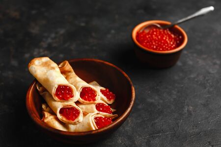 Maslenitsa Maslenitsa week is a holiday of food. Pancakes with red caviar on a wooden plate. The view from the top. side view. space for textの写真素材