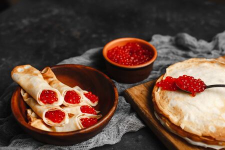 Maslenitsa Maslenitsa week is a holiday of food. Pancakes with red caviar on a wooden plate. The view from the top. side view. space for textの写真素材