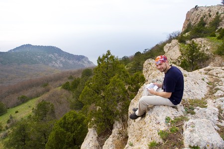 Person climbing sitting on cliff の写真素材