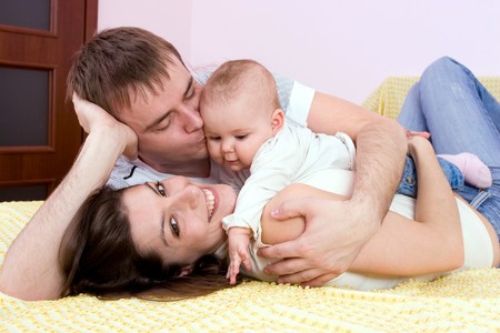 Happy family plays in the bed
