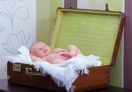newborn baby sleeps in the suitcaseの写真素材