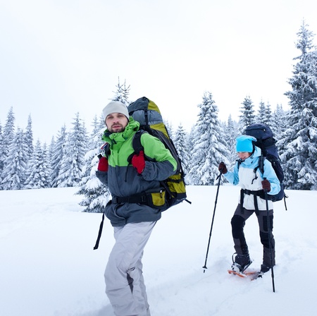 Hiker walks in snow forestの写真素材