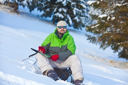 Hiker is looking for the way in winter forestの写真素材