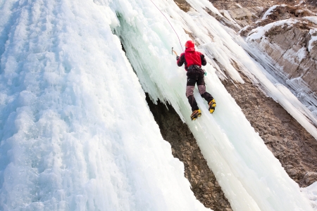 Man climbing frozen waterfallの写真素材