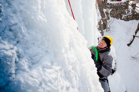 Man climbing frozen waterfallの写真素材
