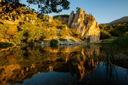 Mountain lake and cliffs beyond it during sunrise in Crimeaの写真素材