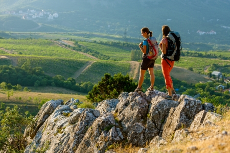 Two women is trekking in the Crimea mountains with backpacksの写真素材
