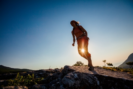 Hiker jumps over the rockの写真素材