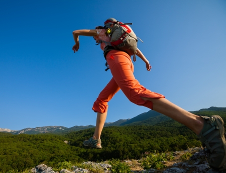 Hiker jumps over the rockの写真素材