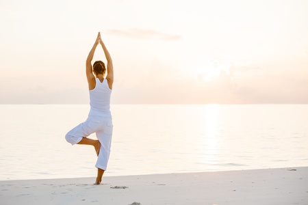 Caucasian woman practicing yoga at seashore Caucasian woman practicing yoga at seashore
