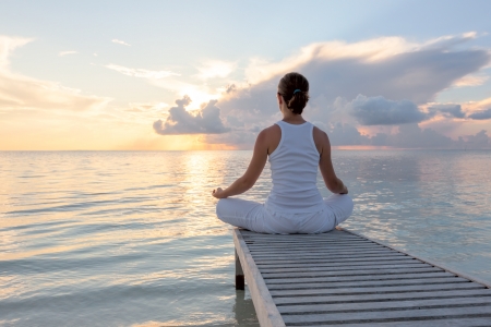 Caucasian woman practicing yoga at seashore Caucasian woman practicing yoga at seashore