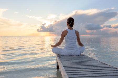 Caucasian woman practicing yoga at seashore