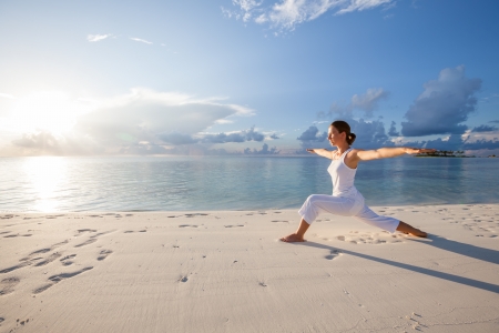 Caucasian woman practicing yoga at seashore