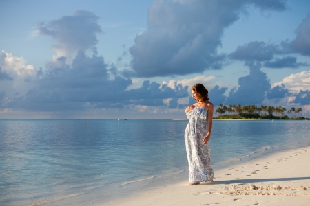 Caucasian woman walks along beautiful seashoreの写真素材