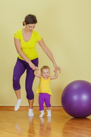 Mother do phisical exercises with her daughter at homeの写真素材