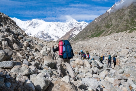 Hikier is jumping on rocks in Caucasus mountains in Bezengi region, Kabardino-Balkaria, Russiaの写真素材