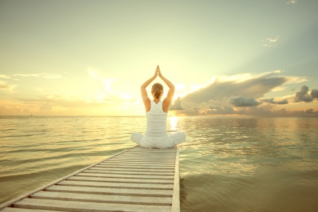 Caucasian woman practicing yoga at seashoreの写真素材