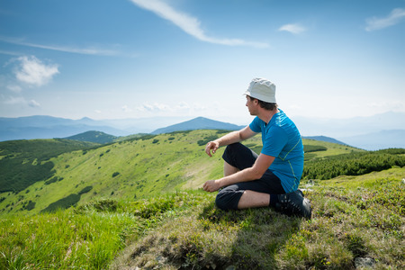 Hiker takes rest during hiking in mountainsの写真素材