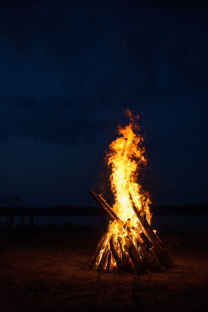 Big campfire at the river after sunset の写真素材