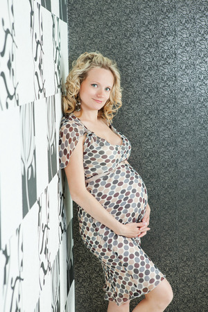 Beautiful pregnant female at home look at the cameraの写真素材
