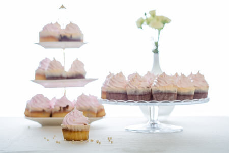 Pink cupcakes at white table  in high light style.の写真素材