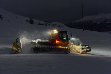 Snowcat cleaning slope in night at snow resort of Gudauri, Georgiaの写真素材