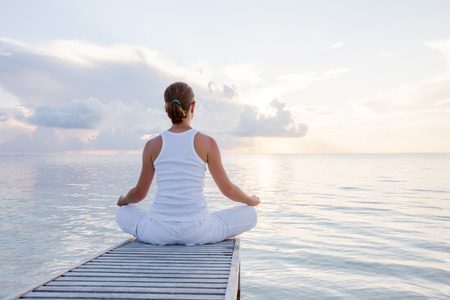 Caucasian woman practicing yoga at seashoreの写真素材