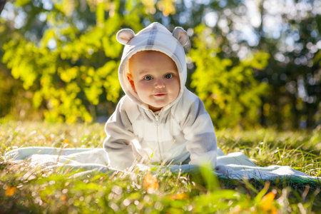 Cute caucasian baby boy in park looks at camera