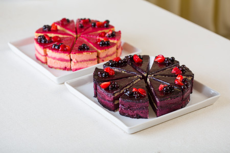 Sweet sliced blueberry and strawberry cake at white plate