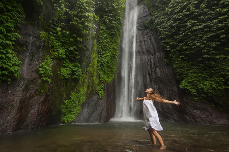 woman meditating doing yoga between waterfalls