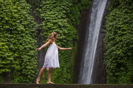 woman meditating doing yoga between waterfallsの写真素材