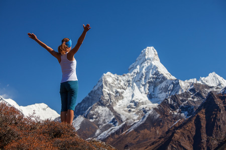 Young woman is practicing yoga against Himalaya mountainsの写真素材