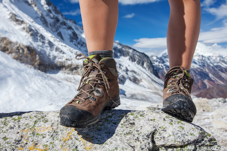 Hiking boot closeup on mountain rocksの写真素材