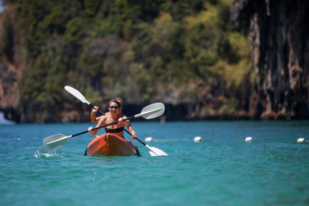 Caucasian woman is kayaking in sea at Thailandの写真素材