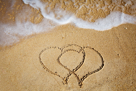 heart on wet golden beach sandの写真素材