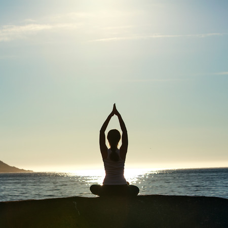 Young woman is practicing yoga between mountains in Norwayの写真素材