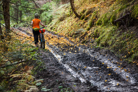 Bikers travel in difficult conditions in autumn forestの写真素材
