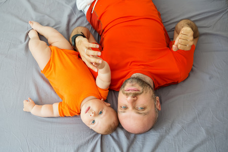 Cute baby boy with his father looking at cameraの写真素材