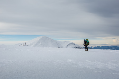 Man hiking in winter mountains before thunderstormの写真素材