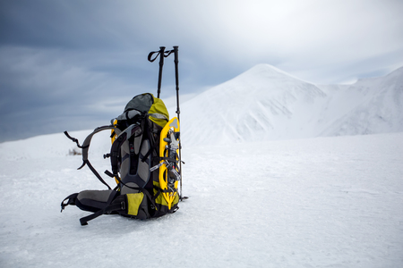 Backpack in wintertime against big snowy mountainの写真素材
