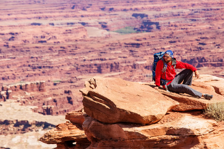 Hiker rests in Canyonlands National park in Utah, USAの写真素材