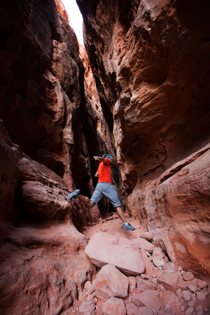 A man jumps from stone in Jenny's canyon within Snow canyon State Park in Utah, USAの写真素材
