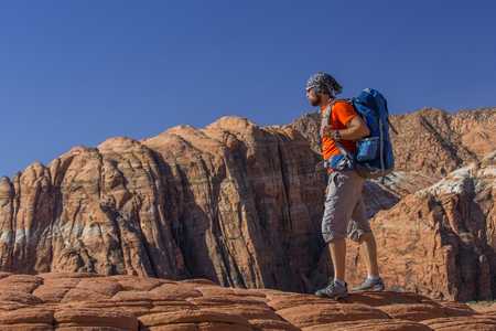 Hiker on a trail in volcanic Snow canyon State Park in Utah, USAの写真素材
