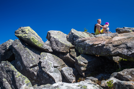 Hikers rest on the stone while hikingの写真素材