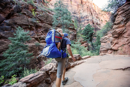 A man with his baby boy are trekking in Zion national park, Utah, USA
