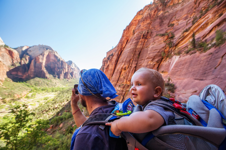 A man with his baby boy are trekking in Zion national park, Utah, USAの写真素材