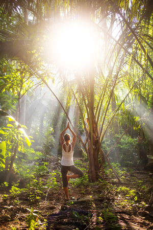 woman doing yoga outside in jungleの写真素材