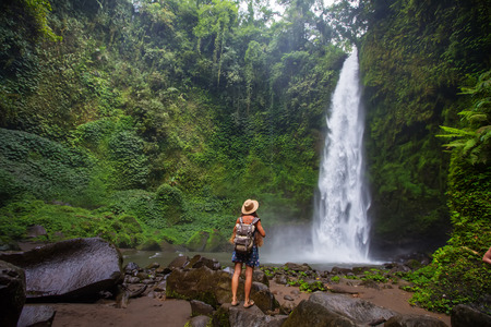 Woman near Nung Nung waterfal on Bali, Indonesiaの写真素材