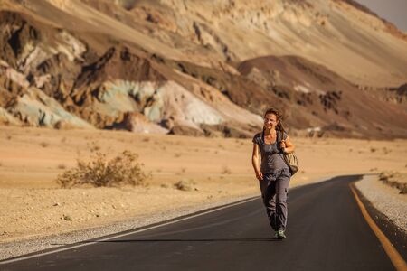 hitchhiker woman walking on a road in USAの写真素材
