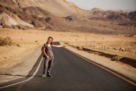 hitchhiker woman walking on a road in USAの写真素材